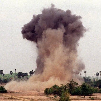A cloud of dust and smoke rises into the sky as deminers from the Cambodian Mine Action Centre, with the help of non-governmental organisation Halo Trust, explode landmines in the western province of Kampong Speu, Cambodia. Photo: AFP