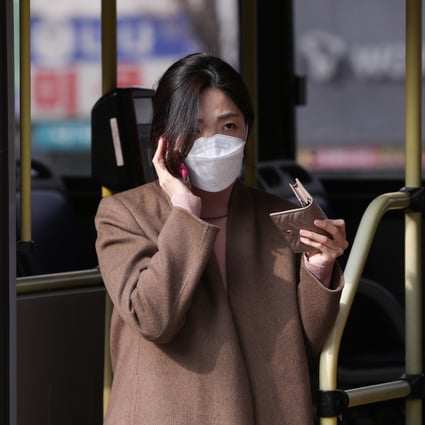 A bus passenger in Seoul wears a face mask as protection from the new coronavirus. Photo: Xinhua