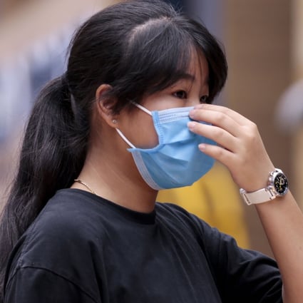 A woman in Sentosa, Singapore, adjusts her face mask, on February 21. An advisory issued by four doctors in Singapore urging the public to wear face mask when going out was refuted by the Singapore Ministry of Health. Photo: EPA-EFE