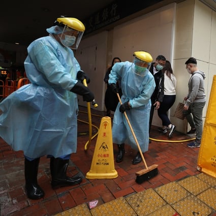 Workers disinfect the pavement outside a location in North Point after another person linked to the Fook Wai Ching She worship hall was confirmed positive for the coronavirus. Photo: Xiaomei Chen