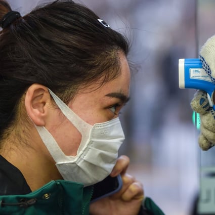 A customer has her temperature checked as she enters a supermarket in Shanghai. Photo: AFP