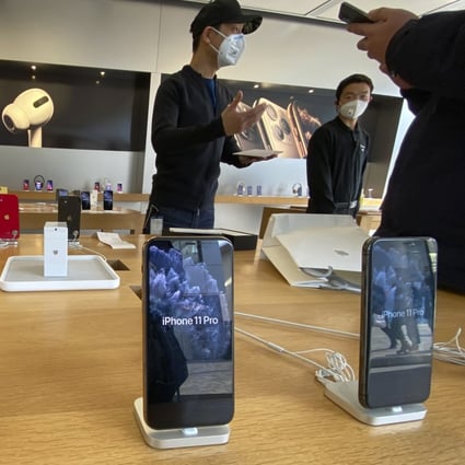 A staff member chats with customers at an Apple Store in Beijing on February 19. Factories that make the world's smartphones, toys and other goods are struggling to reopen after the novel coronavirus outbreak idled China's economy. Photo: AP