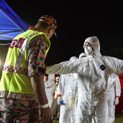 Health workers wearing protective suits as the second batch of Malaysian nationals, evacuated from the Chinese city of Wuhan, the epicentre of the Covid-19 novel coronavirus outbreak, arrived at Kuala Lumpur International Airport on February 26. Photo: Handout