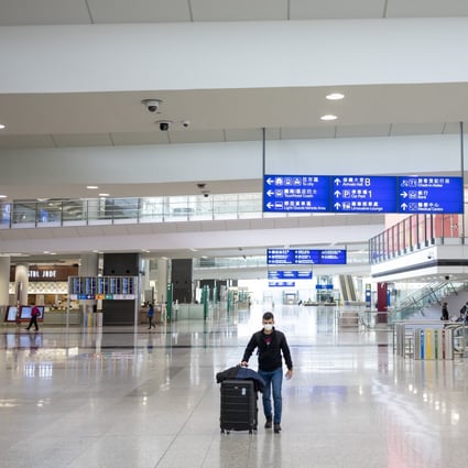 A traveller wearing a protective mask walks through the arrivals hall at Hong Kong International Airport. Photo: Bloomberg
