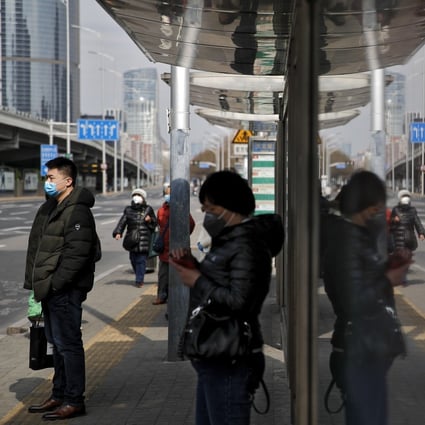 Commuters wearing protective face masks wait for buses at a stop in the Central Business District in Beijing, Monday, March 2, 2020. China's manufacturing plunged in February as antivirus controls shut down much of the world's second-largest economy. Photo: AP