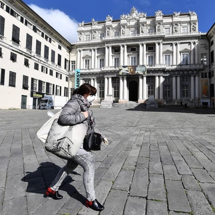 A woman wearing a face mask walks by the almost deserted Ducal Palace square in Genoa, Italy, on Wednesday. Photo: EPA-EFE