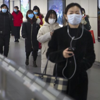 People wearing face masks walk through a subway station in Beijing. Photo: AP