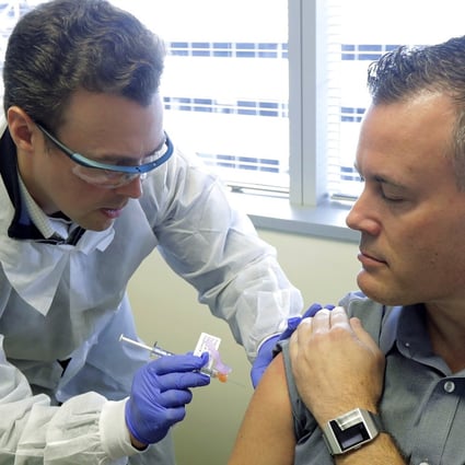 Pharmacist Michael Witte gives Neal Browning a shot in the first-stage study of a potential coronavirus vaccine on Monday in Seattle. Browning is the second patient to receive the shot in the study. Photo: AP