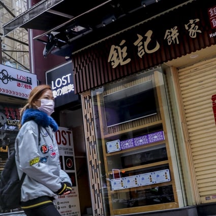 A pedestrian in a protective face mask walks past a closed up bakery in Causeway Bay, one of Hong Kong’s main shopping districts. Photo: Winson Wong