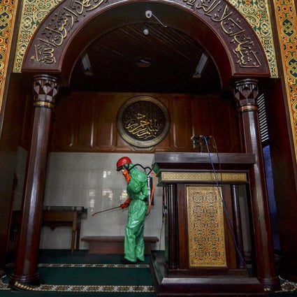 A worker sprays disinfectant in mosque amid the coronavirus outbreak in Indonesia. Thousands of Muslim pilgrims have gathered in Gowa, near the provincial city of Makassar. Photo: Reuters