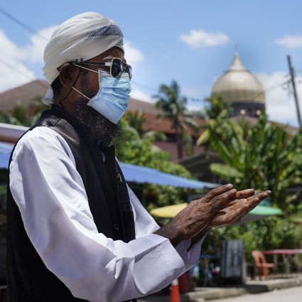 A man sanitises his hands as he leaves Sri Petaling Mosque in Kuala Lumpur, where hundreds of cases of coronavirus have been linked to a mass prayer event. Photo: AP