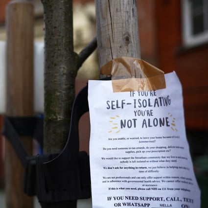 A sign is seen down a London street regarding self isolation. Photo: Reuters