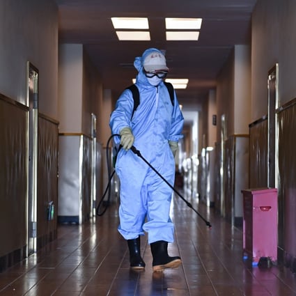 A worker disinfects the corridor of a hotel used for health checks in Shenzhen on Saturday. Authorities are now focused on imported cases. Photo: Xinhua
