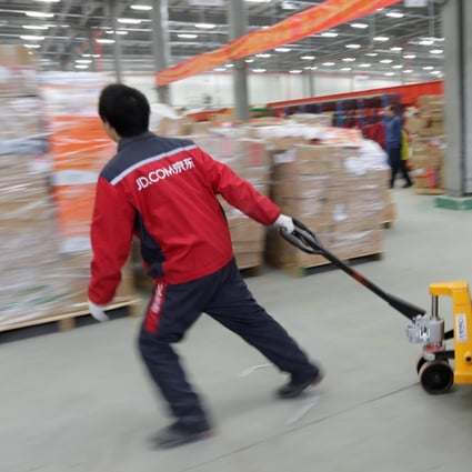 A worker moves goods at a JD.com logistics centre in Langfang, Hebei province. Photo: Reuters