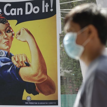A man wearing a protective mask walks beside a poster of American WWII icon Rosie the Riveter at the Quezon city hall in the Philippines. Photo: AP