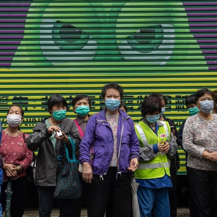 Street cleaners in Hong Kong wait in line to receive free face masks amid the coronavirus outbreak. Photo: EPA-EFE
