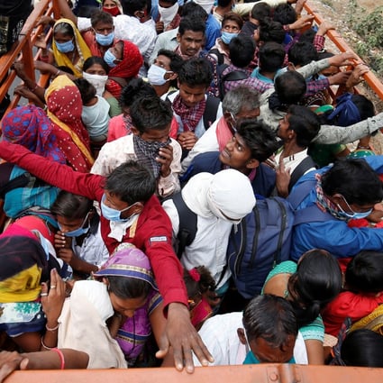 Migrant workers and their families board a truck in Ahmedabad on March 25 to return to their villages after India orders a 21-day nationwide lockdown to limit the spreading of Covid-19. Photo: Reuters