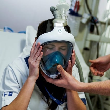 A medical worker tests a Decathlon snorkelling mask upgraded with 3D-printed respiratory valve fittings. Photo: AFP