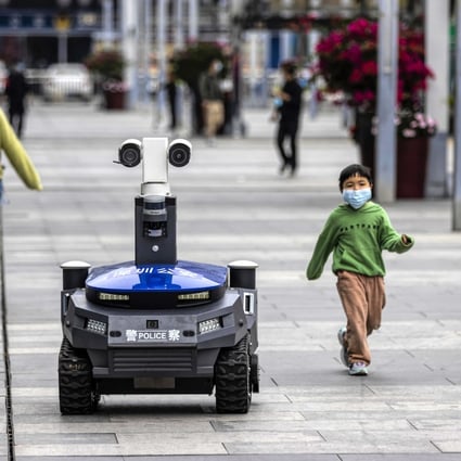 A police security robot patrols near the high-speed railway station in Shenzhen on March 6. It can warn people if they are not wearing masks, and check their body temperature and identity. Photo: EPA-EFE