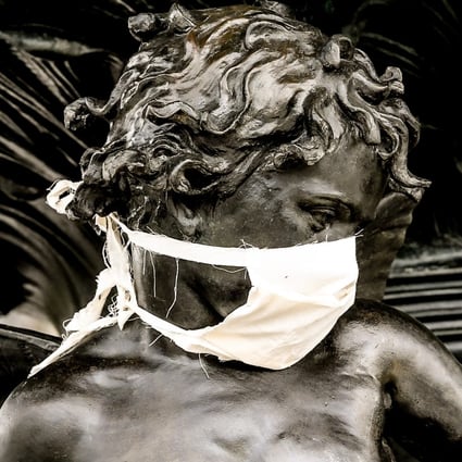 A bronze statue is decorated with a face mask in central Dresden, Germany. The German government and local authorities are heightening measures to stem the spread of the coronavirus which causes the Covid-19 disease. Photo: EPA