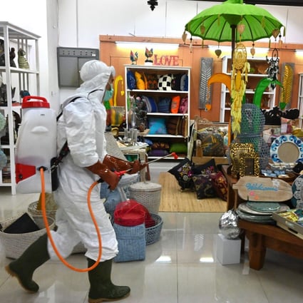 A member of the Indonesian Red Cross sprays disinfectant at a mall in Jakarta. Photo: AFP