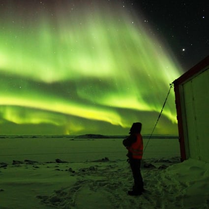 An expeditioner watches the Aurora Australis at the ADD's Davis Station in Antarctica, the only coronavirus-free continent. Photo: AFP