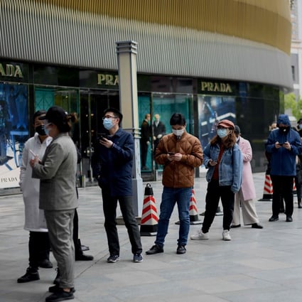 People wearing face masks queue to enter a supermarket in Wuhan, in China’s central Hubei province on March 30, 2020. Photo AFP