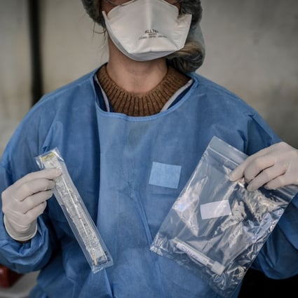 A nurse holds up a sample collected from a person at a Covid-19 screening station in Paris on Monday. Photo: AFP