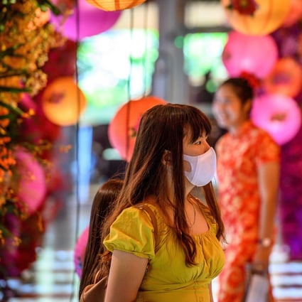 A woman in a face mask walks through a shop decorated for the Lunar New Year in Bangkok on January 24. Photo: AFP