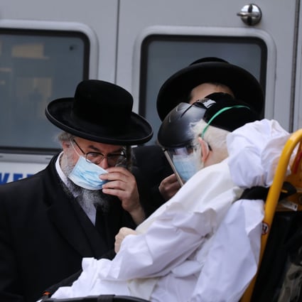 Hasidic men speak with an elderly patient being brought into Mount Sinai Hospital amid the coronavirus pandemic on April 1, 2020 in New York City. Photo: Agence France-Presse