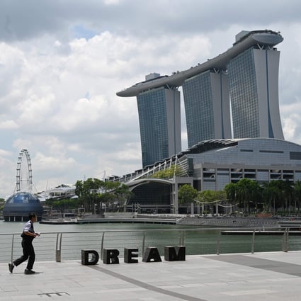 A man jogs on the promenade along Marina Bay in Singapore. The island nation is slowly tightening restrictions to combat the spread of Covid-19. Photo: Agence France-Presse