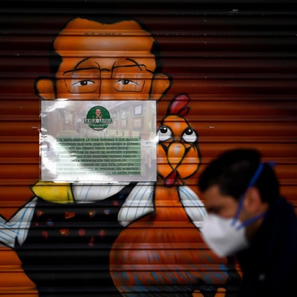 A man wearing a face mask walks past a closed restaurant in Madrid amid a national lockdown to fight the spread of Covid-19. Photo: AFP