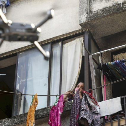 A woman watches a drone, used by the Malaysian police to remind people to stay at home during a lockdown imposed to contain the spread of Covid-19, in Kuala Lumpur on March 24. Photo: Reuters