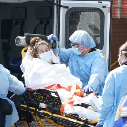 A woman arrives in an ambulance at a hospital in New York on Sunday. Photo: AFP