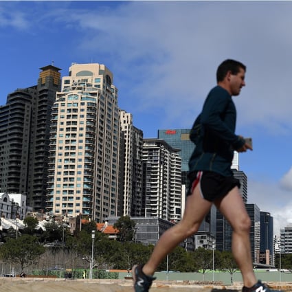 A man jogs in front of newly constructed residential and commercial projects in Sydney. Overseas properties have become cheaper as regional currencies weakened against Hong Kong’s pegged dollar. Photo: AFP