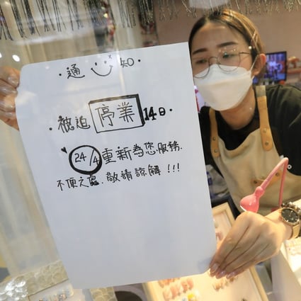 Tang Tze-ching puts up a sign saying the nail salon she works at in New Town Mall, Mong Kok, will be closed for 14 days because of government rules designed to slow the spread of the coronavirus. Photo: May Tse