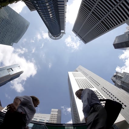 People walk past office buildings in the central business district in Singapore. Photo: Reuters