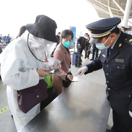 Officials at Wuhan Railway Station check passenger codes as the city’s travel lockdown lifts. Photo: Simon Song