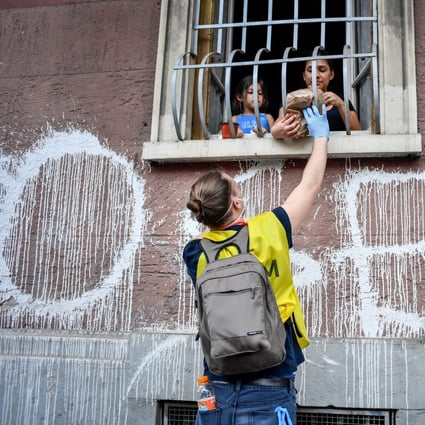 A volunteer distributes basic necessities to people during a lockdown in Milan, Italy. Photo: DPA