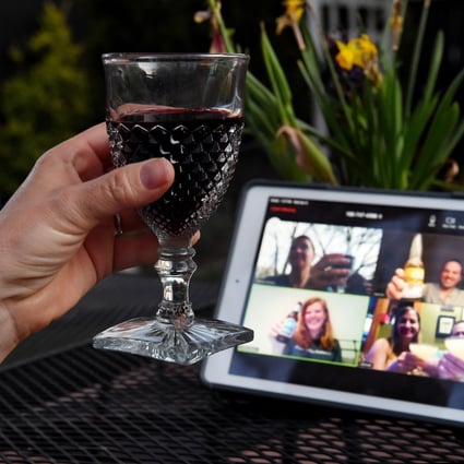 A woman lifts her glass to share a toast with friends online via the Houseparty app during a virtual happy hour on April 8 in Arlington, Virginia. Photo: AFP
