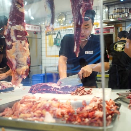 Workers cut beef in Shenzhen, Guangdong. Photo: Reuters