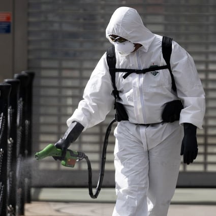A cleaner sprays disinfectant outside an office in central London. As the coronavirus pandemic takes hold, the previously “invisible’’ cleaners, garbage collectors, sanitation officers and health care workers now occupy centre-stage. Photo: EPA-EFE