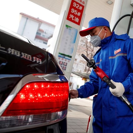 A pump attendant wears a mask as he refuels a car at a Sinopec gas station in China. The price of oil has plunged amid the coronavirus outbreak. Photo: Reuters