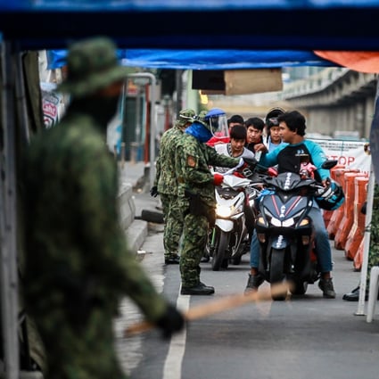Philippine police dressed in camouflage stop motorcyclists at a checkpoint in Antipolo City earlier this month. Photo: Xinhua