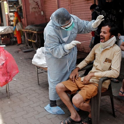 A doctor collects a swab sample from a man in India’s Mumbai. Photo: Reuters