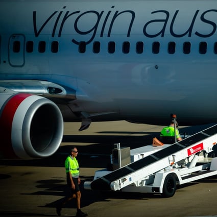 Baggage handlers prepare to unload freight from a Virgin Australia aircraft on the tarmac at Brisbane International airport on April 21. The cash-strapped carrier collapsed on April 21, making it the largest carrier in Asia-Pacific yet to buckle under the strain of the coronavirus pandemic. Photo: Agence France-Presse