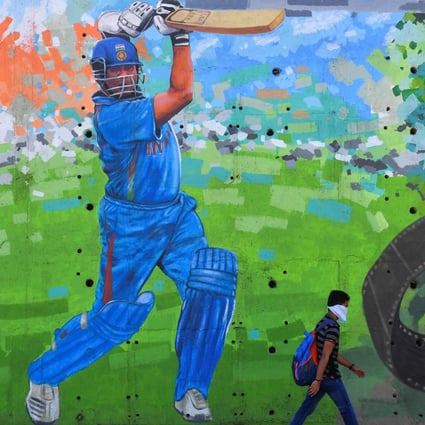 A man wearing a face mask walks past a mural of Indian cricketing legend Sachin Tendulkar in Mumbai on March 19. India’s 700-million-strong youth population could provide a ready talent pool for the provision of services internationally. Photo: AFP