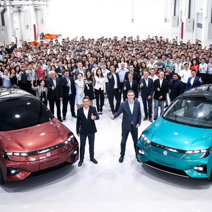 Byton founder and chief executive Daniel Kirchert, on the right foreground, poses with the company’s staff and a pair of electric vehicles at its headquarters in Nanjing, capital of eastern coastal Jiangsu province. Photo: Handout