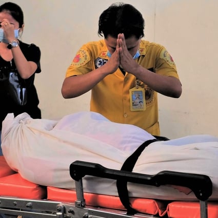 Pattipan Boonyee, a mortuary cosmetologist, performs a respectful prayer over the corpse of a schoolboy who was murdered in the town of Sri Racha in eastern Thailand. Photo: Tibor Krausz