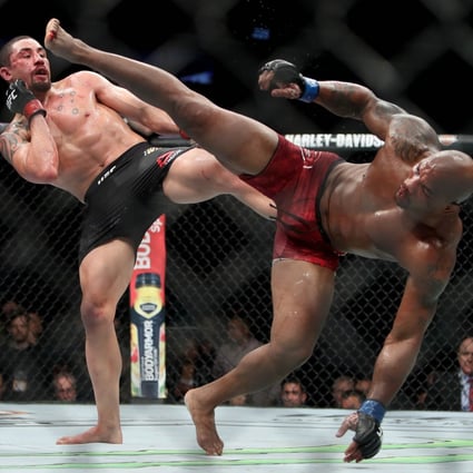 Robert Whittaker and Yoel Romero each attempt a kick in the fifth round of their middleweight title fight at UFC 225. Photo: AFP
